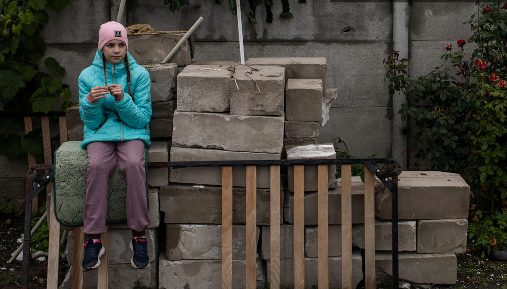 Una niña de nueve años descansa mientras ayuda a su madre a limpiar su casa, destruida en su mayor parte por los bombardeos en Chernihiv (Ucrania).