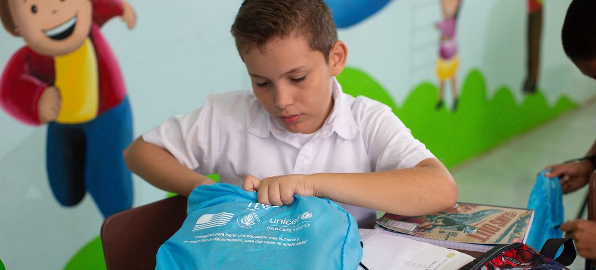 Juan Pablo Moreno (10) busca sus útiles dentro del bolso, que forma parte de los kits de aprendizaje donados por UNICEF para toda la población estudiantil que incluye un set de uniformes y materiales escolares. 
